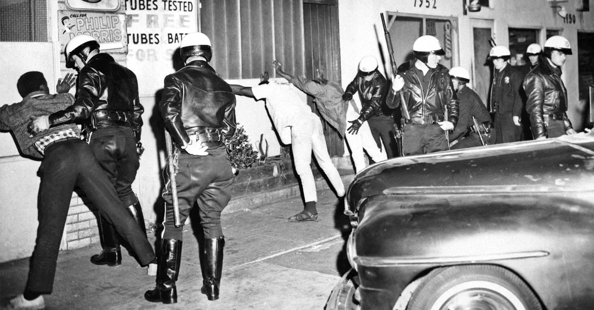  La polizia perquisisce uomini nel distretto Watts di Los Angeles nel marzo 1966, sette mesi dopo gli scontri tra polizia e residenti che divennero noti come i Watts Riots e che furono seguiti da continue tensioni e violenze nella comunità.